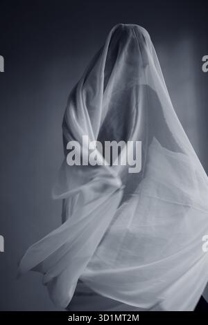 Donna con un panno bianco largo, costume fantasma Foto Stock
