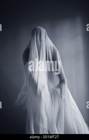 Donna con un panno bianco largo, costume fantasma Foto Stock