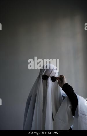 Donna con un panno bianco largo, costume fantasma Foto Stock