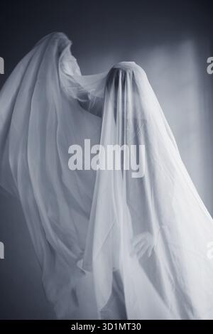 Donna con un panno bianco largo, costume fantasma Foto Stock