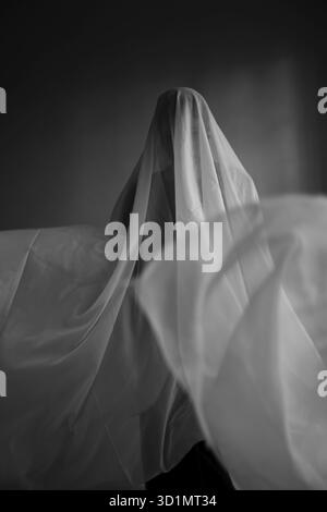 Donna con un panno bianco largo, costume fantasma Foto Stock