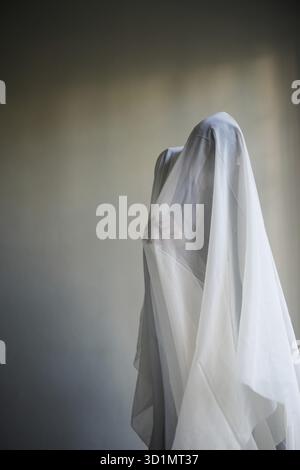Donna con un panno bianco largo, costume fantasma Foto Stock