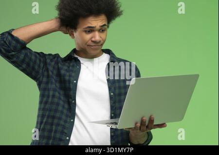 Tecnologia. Giovane afroamericano in camicia a scacchi con un portatile Foto Stock