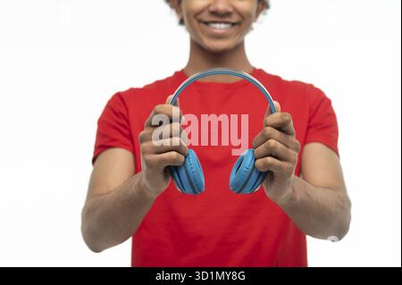 Tempo libero. Giovane ragazzo dalla pelle scura con cuffie che sembrano contenti Foto Stock
