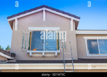 Scala appoggiata contro Una casa pronta per la nuova verniciatura Foto Stock