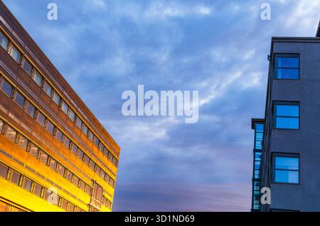 La luce calda del sole che sorge bagna gli eleganti edifici di uffici di Gothenburg, Svezia, evidenziandone le caratteristiche architettoniche e creando un seren Foto Stock