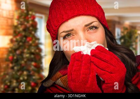 Donna malata che soffia il naso con tessuto in ambiente natalizio Foto Stock
