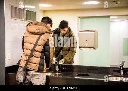 Riflesso dell'uomo che lava le mani in bagno Foto Stock