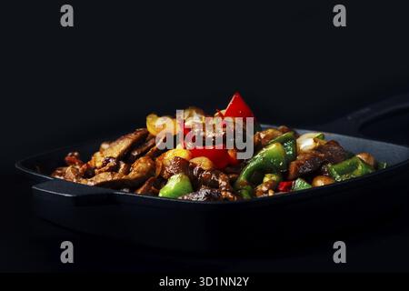 Impasto fritto di carne e verdure in padella di ghisa Foto Stock