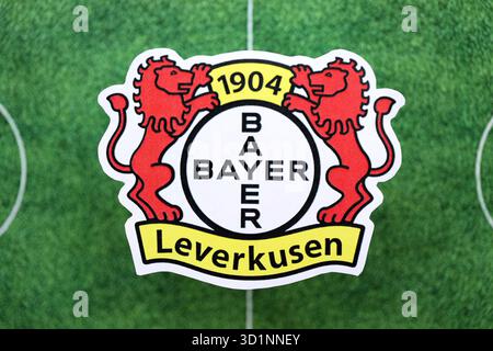 KIEV, UCRAINA - 23 FEBBRAIO 2025 il distintivo della squadra di calcio Bayer 04 Leverkusen si trova sullo sfondo del campo di calcio Foto Stock
