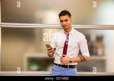 Bel giovane uomo d'affari che usa il cellulare Foto Stock