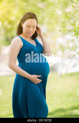 Giovane donna cinese incinta Ritratto a Park Foto Stock