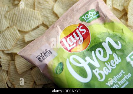 KIEV, UCRAINA - 19 APRILE 2025 giace lo yogurt al forno con patatine aromatizzate all'erba in una confezione verde con il logo ufficiale Foto Stock