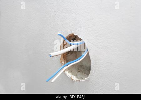 Fili elettrici nel foro della parete, nel copyspace, nella messa a fuoco selettiva Foto Stock