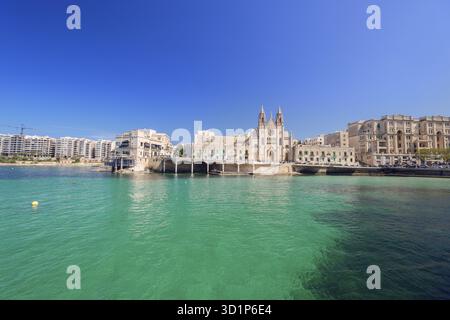 Chiesa parrocchiale carmelitana neogotica e edifici Balluta a Balluta Bay, St Julian's, Malta Foto Stock