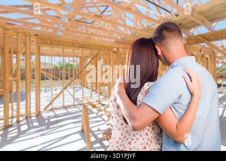 Giovane coppia militare sul sito interno della loro nuova casa Costruzione Framing. Foto Stock