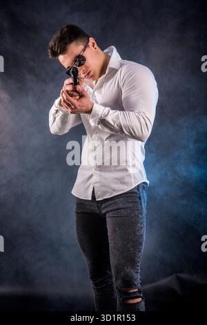 Giovane uomo pistola di puntamento Foto Stock