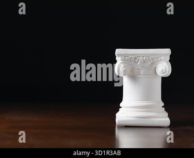 Colonna di design ionica bianca su sfondo scuro Foto Stock
