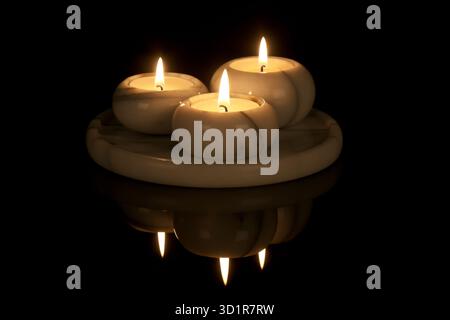 Candelabro decorativi di marmo con tre luci a uno sfondo nero Foto Stock