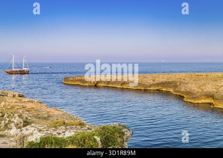 Nave a vela e la costa di polignano in Puglia in Italia Foto Stock
