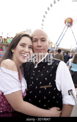Donna felice appoggiata al fidanzato marito all'Oktoberfest di Monaco di Baviera, Germania, Europa, coppia multiculturale, desitazione di viaggio, felice eccitazione, vibran Foto Stock
