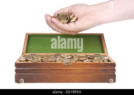 Mano piena di monete su un tesoro Foto Stock