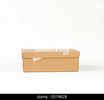 Scatola di cartone Kraft marrone chiusa su sfondo bianco Foto Stock