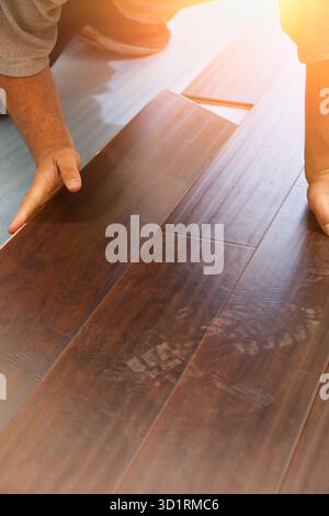 Uomo che installa nuovi pavimenti in legno laminato Foto Stock