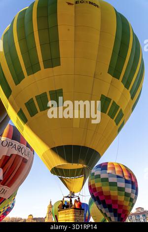Guadix, Granada - Spagna - 01-24-2024: Una mongolfiera giallo-verde sale lentamente, piena di aria calda. Il cestino trasporta i passeggeri, incluso un p Foto Stock