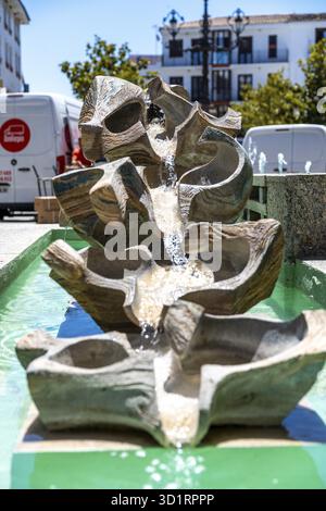 Ronda, Malaga - Spagna - 06-04-2024: Una fontana moderna a Ronda, Spagna, presenta un design astratto con acqua a cascata che scorre tra le sculture Foto Stock