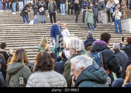 Roma, Lazio - Italia - 11-27-2022: Una coppia si scambia i voti su gradini storici, circondati da un pubblico di ospiti invitati e spettatori occasionali, u Foto Stock