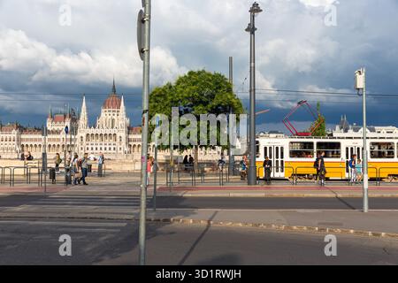 La fermata del tram lungo il Danubio e ungherese opposto del Palazzo del Parlamento Foto Stock