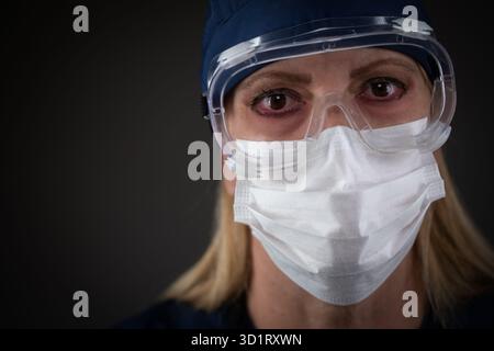 Lavoratore medico donna che indossa l'attrezzatura protettiva che mostra i sintomi della malattia Foto Stock