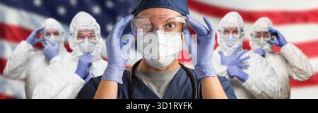 Medici o infermieri che indossano i dispositivi di protezione individuale (DPI) contro l'American Flag Banner Foto Stock
