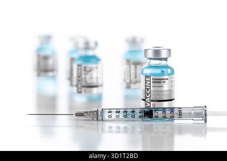 Flaconcini e siringhe per il vaccino del coronavirus COVID-19 su superficie riflettente Foto Stock