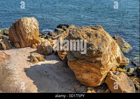 Grandi massi di roccia conchiglia sulla riva del mare Foto Stock