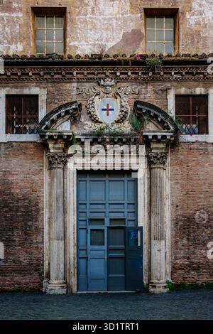 Porta storica della Chiesa di San Crisogono a Trastevere, Roma, Italia, con colonne classiche, uno stemma decorativo a croce Foto Stock
