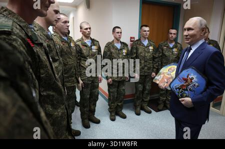 Mosca, Russia. 29 ottobre 2025. Il presidente russo Vladimir Putin, parla con i militari con la 127a brigata di ricognizione separata durante una visita al Mandryk Central Military Clinical Hospital, il 29 ottobre 2025 a Mosca, Russia. I soldati hanno dato a Putin icone religiose con schegge e proiettili per il suo compleanno. Crediti: Vyacheslav Prokofyev/piscina del Cremlino/Alamy Live News Foto Stock