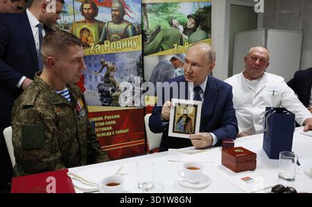 Mosca, Russia. 29 ottobre 2025. Il presidente russo Vladimir Putin, centro, detiene l'icona di St. Alexander Nevsky mentre parla ai soldati con la 127a brigata di ricognizione separata durante il pranzo presso il Mandryk Central Military Clinical Hospital, il 29 ottobre 2025 a Mosca, Russia. Crediti: Vyacheslav Prokofyev/piscina del Cremlino/Alamy Live News Foto Stock