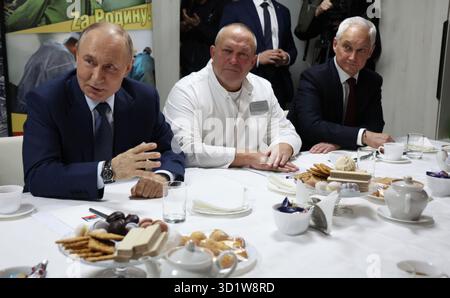 Mosca, Russia. 29 ottobre 2025. Il presidente russo Vladimir Putin, a sinistra, parla con i soldati della 127a brigata di ricognizione separata durante il pranzo al Mandryk Central Military Clinical Hospital, il 29 ottobre 2025 a Mosca, Russia. Da sinistra a destra: Il presidente Vladimir Putin, il capo dell'ospedale Pavel Krainyukov e il ministro della difesa Andrei Belousov. Crediti: Vyacheslav Prokofyev/piscina del Cremlino/Alamy Live News Foto Stock
