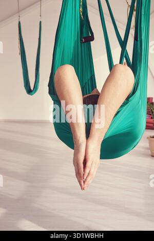 Persona maschile fare amaca yoga lezione di esercizio. Meditazione in aria calma Foto Stock