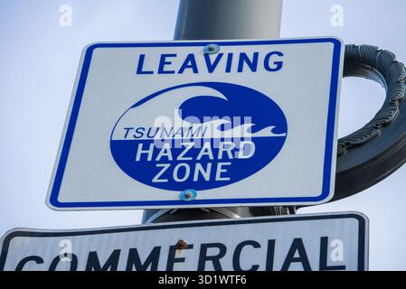 Lasciando il cartello della zona di pericolo dello tsunami sopra il cartello commerciale di San Francisco Foto Stock