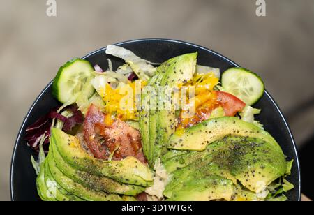 Insalata di verdure con avocado fresco con cetrioli e pomodori Foto Stock