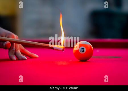 Fiamme sul feltro: Fuoco caos come tavolo da biliardo esplode con palle ardenti e fumo in aumento Foto Stock