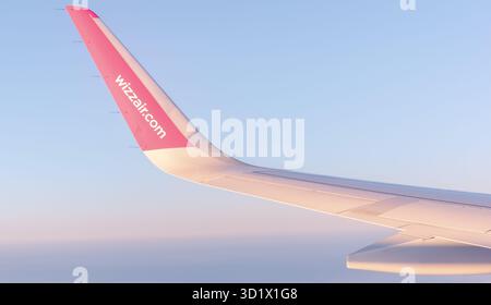 Vista dalla finestra dell'aereo: Ala dell'aereo "wizzair" nel cielo nuvoloso. Wizz Air è una delle compagnie aeree a basso costo con sede in Ungheria Foto Stock
