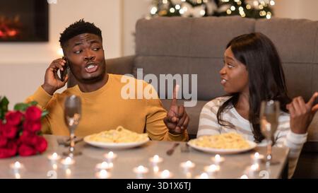 Una donna scontenta litiga con Man on Phone durante un Bad Date Indoors Foto Stock