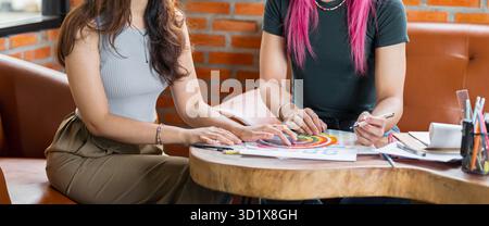 LGBTQ+ transgender uomo bello autentico Specialista con capelli rosa e trans non binari che lavorano insieme Design in cr Foto Stock