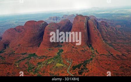 Vista aerea di Kata Tjuta (Olgas) nel Parco Nazionale Uluru-Kata Tjuta, territorio settentrionale, con Uluru visibile in lontananza Foto Stock