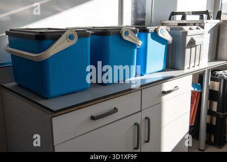 Accessori e contenitori posizionati su un banco da laboratorio, utilizzati per la raccolta e la conservazione di campioni d'acqua per l'analisi ambientale. Foto Stock