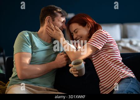 Una coppia positiva di mezza età che ride scherzosamente l'una all'altra. Connessione emotiva in famiglia. Foto Stock
